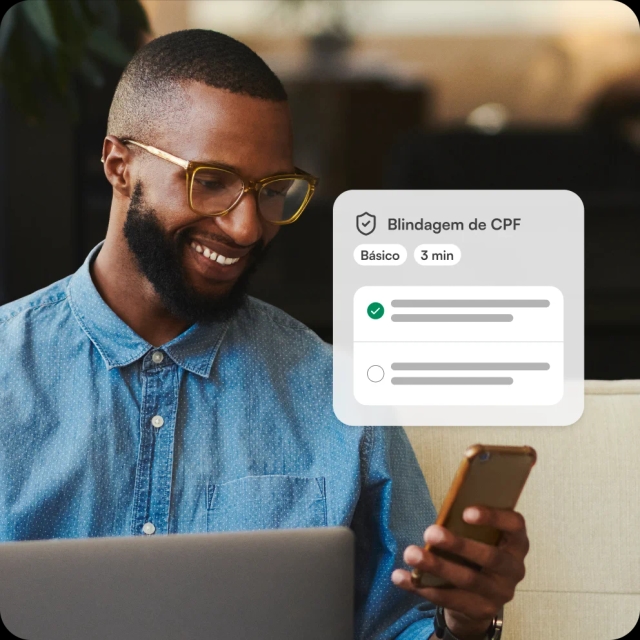 Homem sorrindo usando o celular, com interface de “Blindagem de CPF” exibida ao lado.