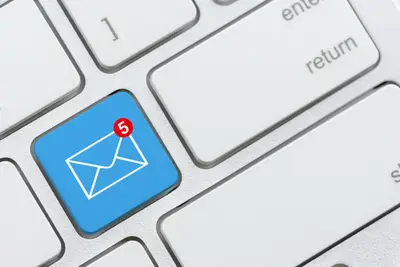 Teclado de computador com foco na tecla de email destacada, indicando notificações de mensagens importantes, ideal para quem busca gerenciar e-mail eficientemente.